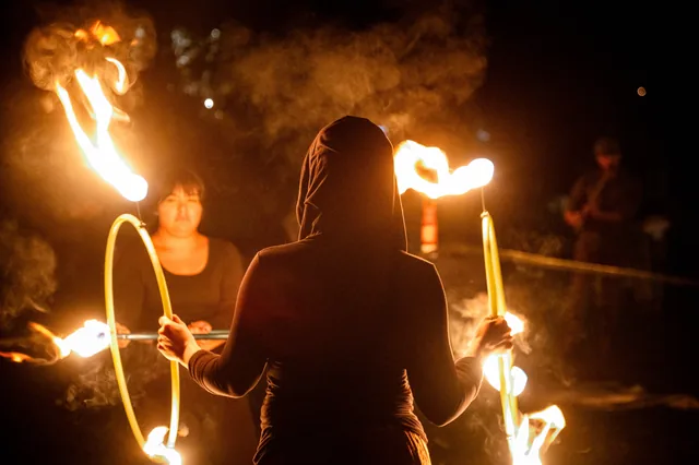 A hooded silhouette between flames