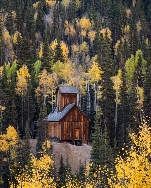 An old mine framed by autumn forest