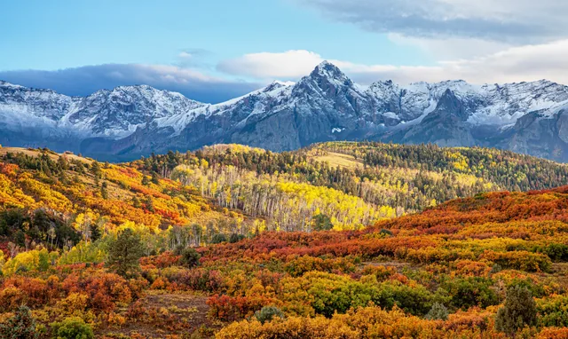 Autumn color below a snowy mountain wall
