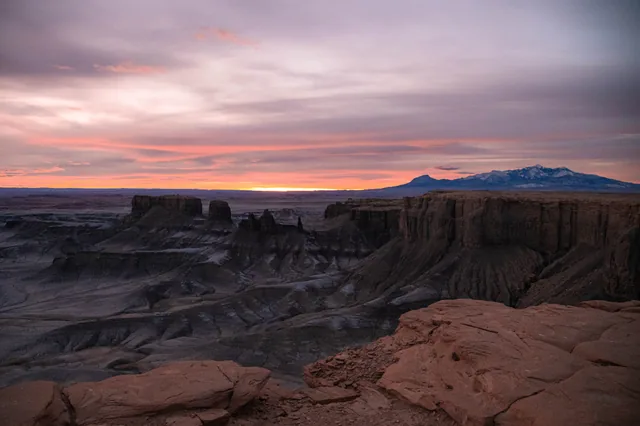 Badlands beneath a pink dawn sky