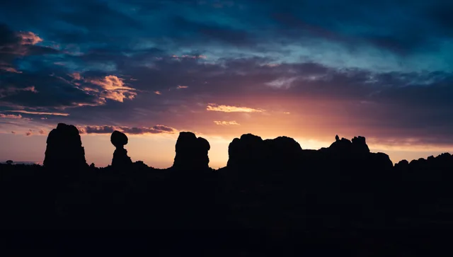 Desert silhouettes beneath a luminous sunset