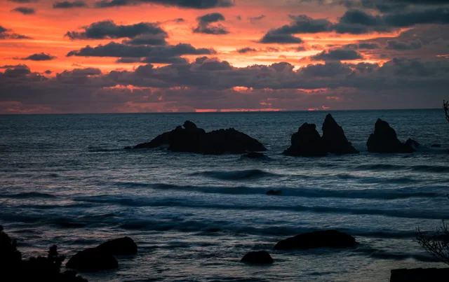 Fiery clouds above silhouetted sea stacks