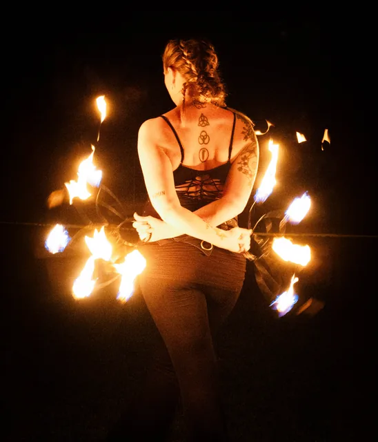 Fire fans framing a quiet pose