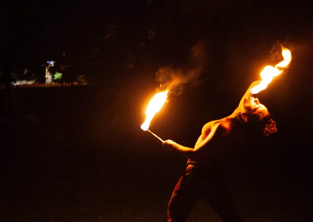 Fire performer arching into the light
