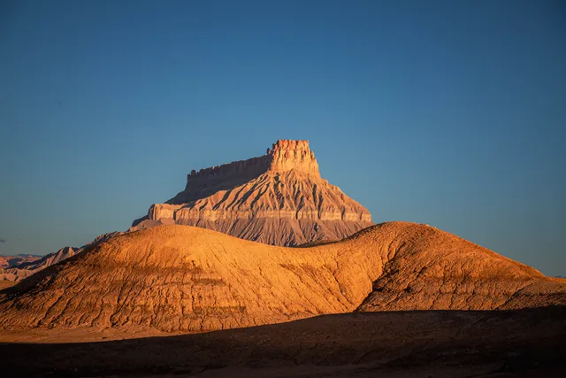 Golden folds beneath a desert tower