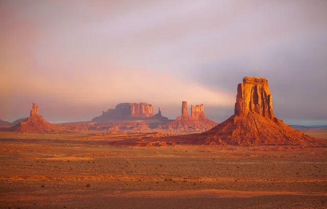 Monument Valley glowing beneath pastel clouds