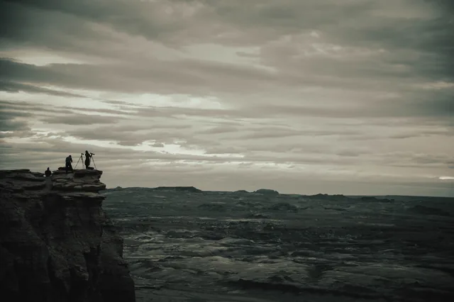 Photographers above a vast desert