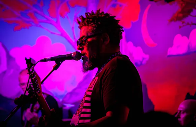 Singer in vivid magenta stage light