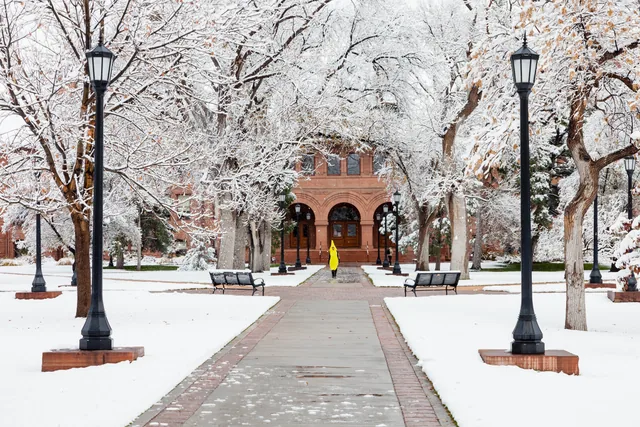 Snowy campus and a yellow-coated figure